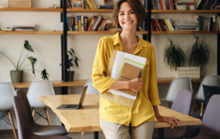 woman holding files standing in an office