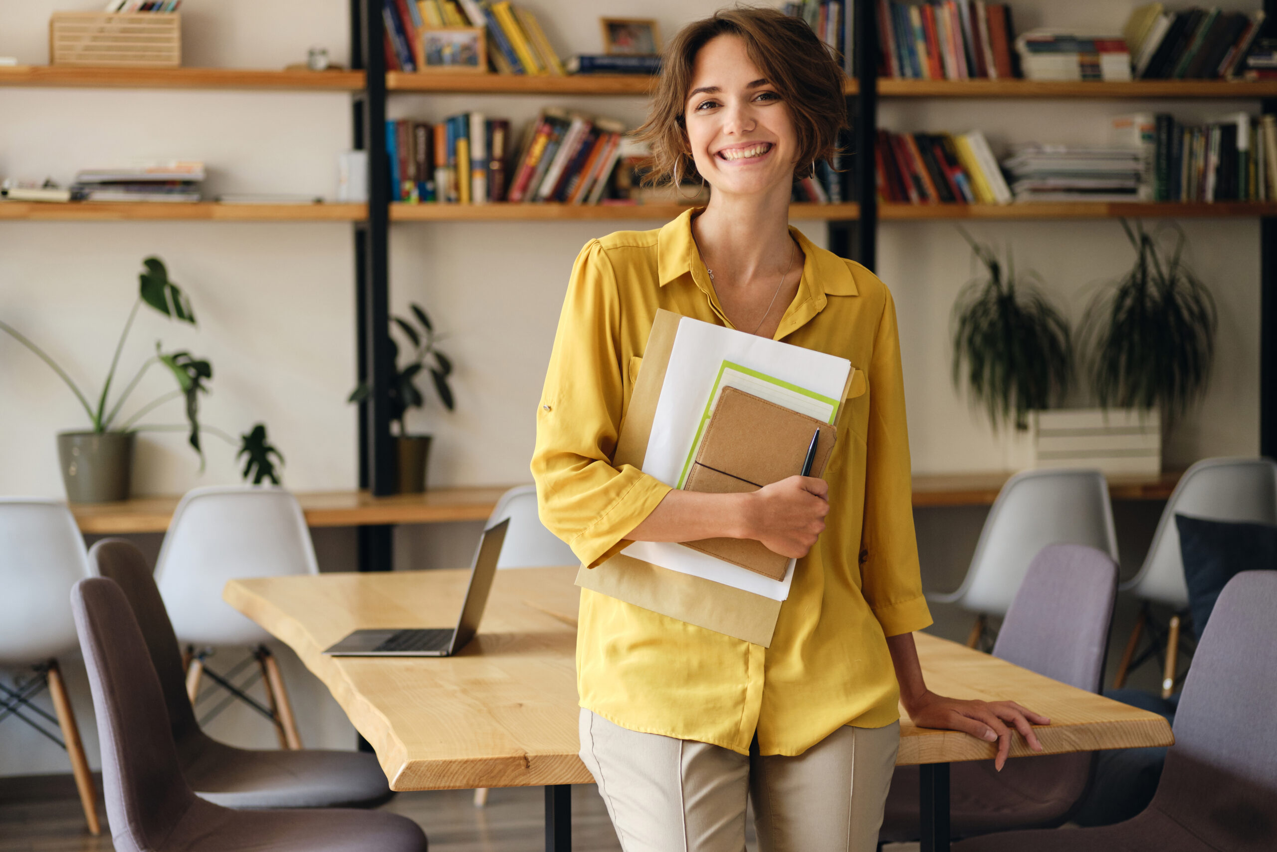 woman holding files standing in an office